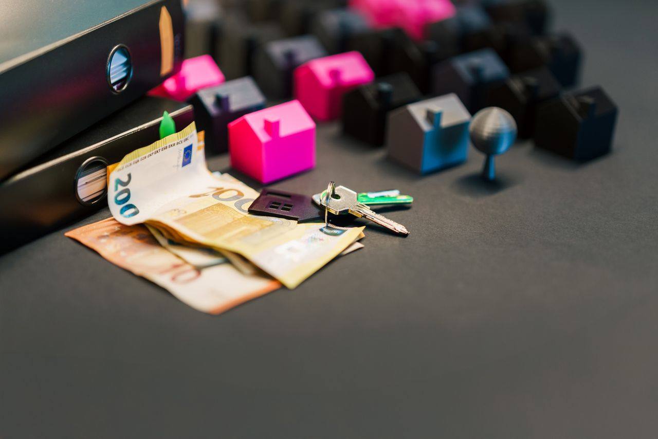 Model houses, house keys and bank notes representing home improvement finance
