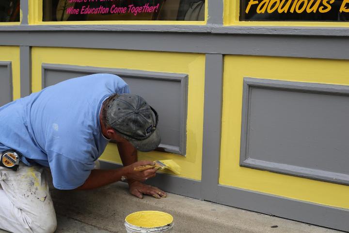 Painter brushing fresh paint onto a shopfront