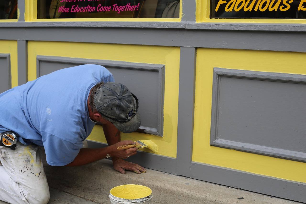 Painter brushing fresh paint onto a shopfront