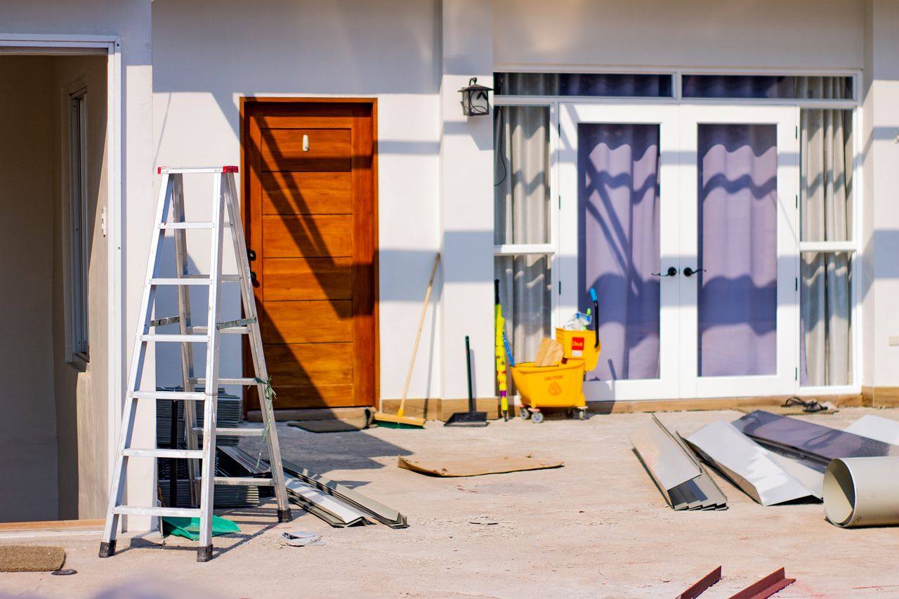 Home exterior during renovation with a new front door and French doors