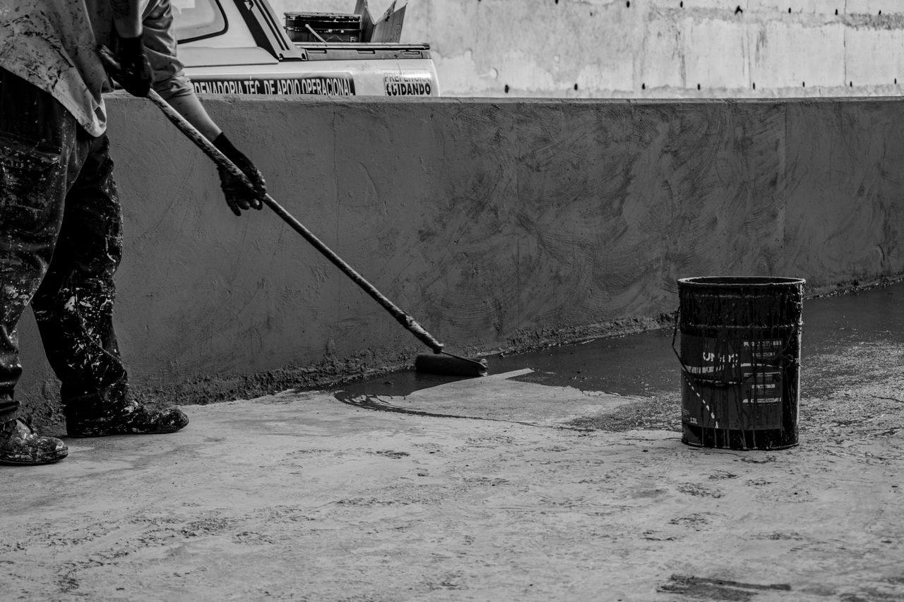 Waterproofing sealant being rolled onto concrete